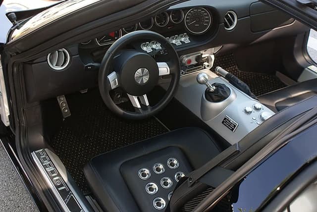 Interior of a 2006 Ford GT, showing the steering wheel, dashboard, and gear shifter.