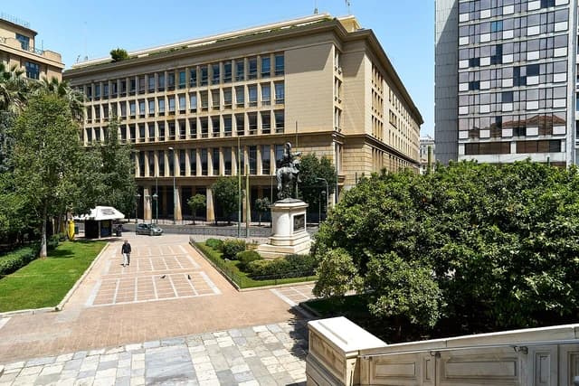 Bank of Greece building on Stadiou Street, Athens, with a statue in the foreground.