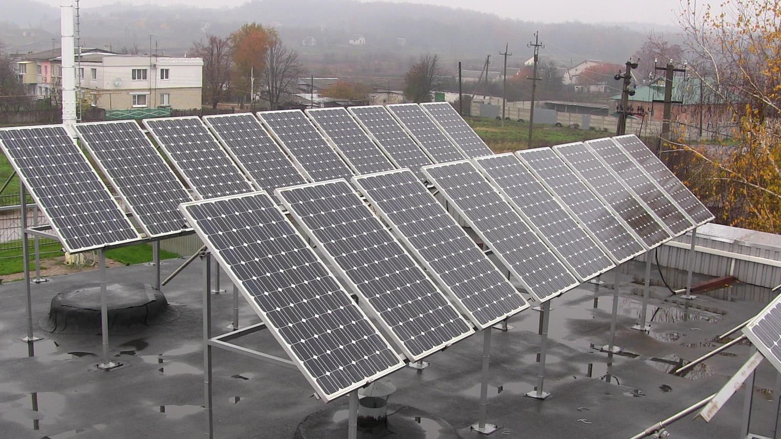 Rooftop solar power plant with multiple photovoltaic panels on a building.