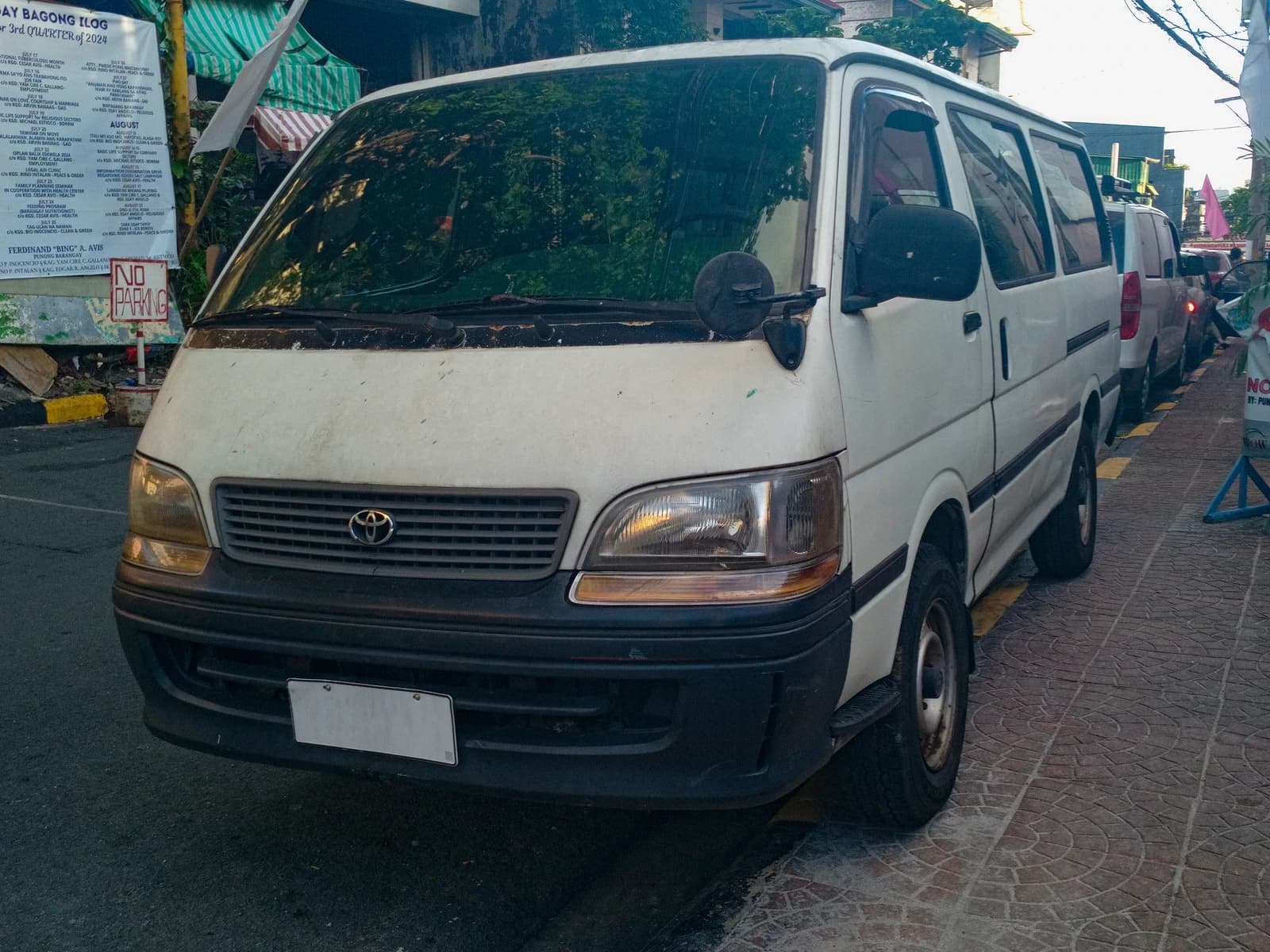 Toyota Hiace H100 van, white, parked on the street, front left view.
