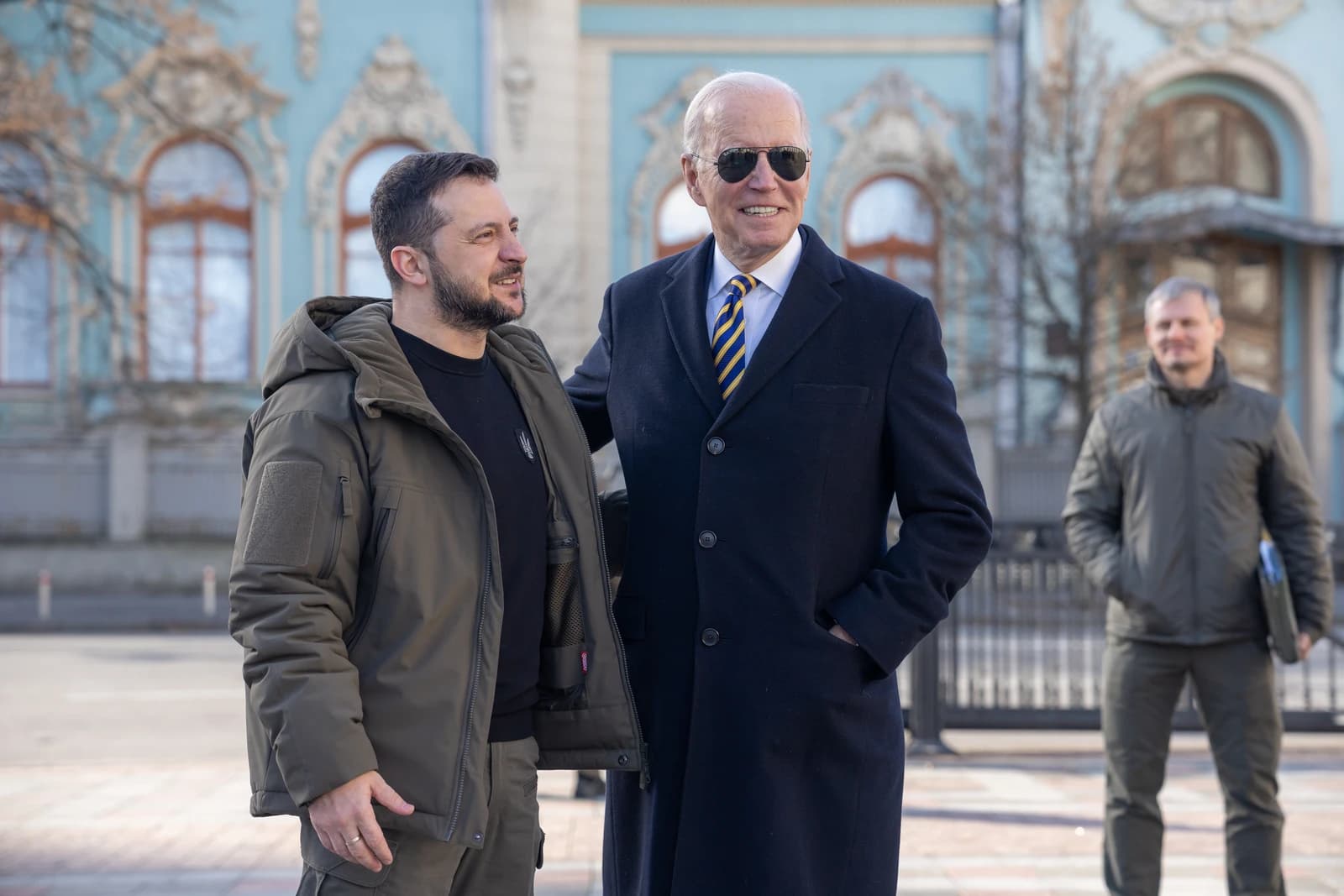 President Joe Biden and President Volodymyr Zelenskyy standing together and smiling outdoors.