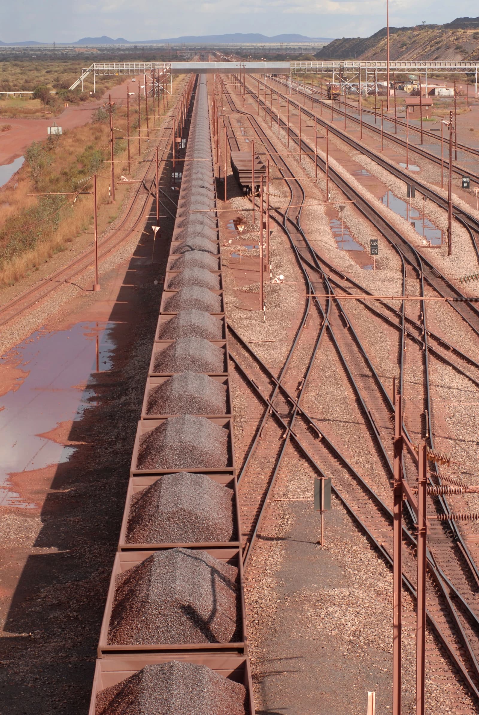 Long freight train loaded with iron ore on tracks at Sishen Mine, South Africa.