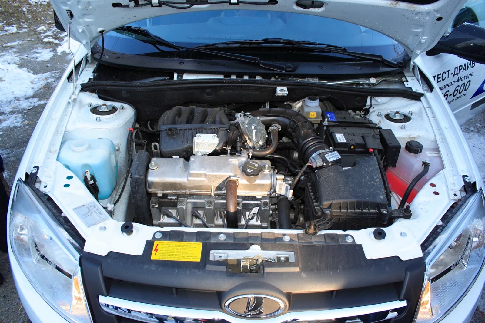 Engine of a Lada Granta vehicle with the hood raised, viewed from the front.