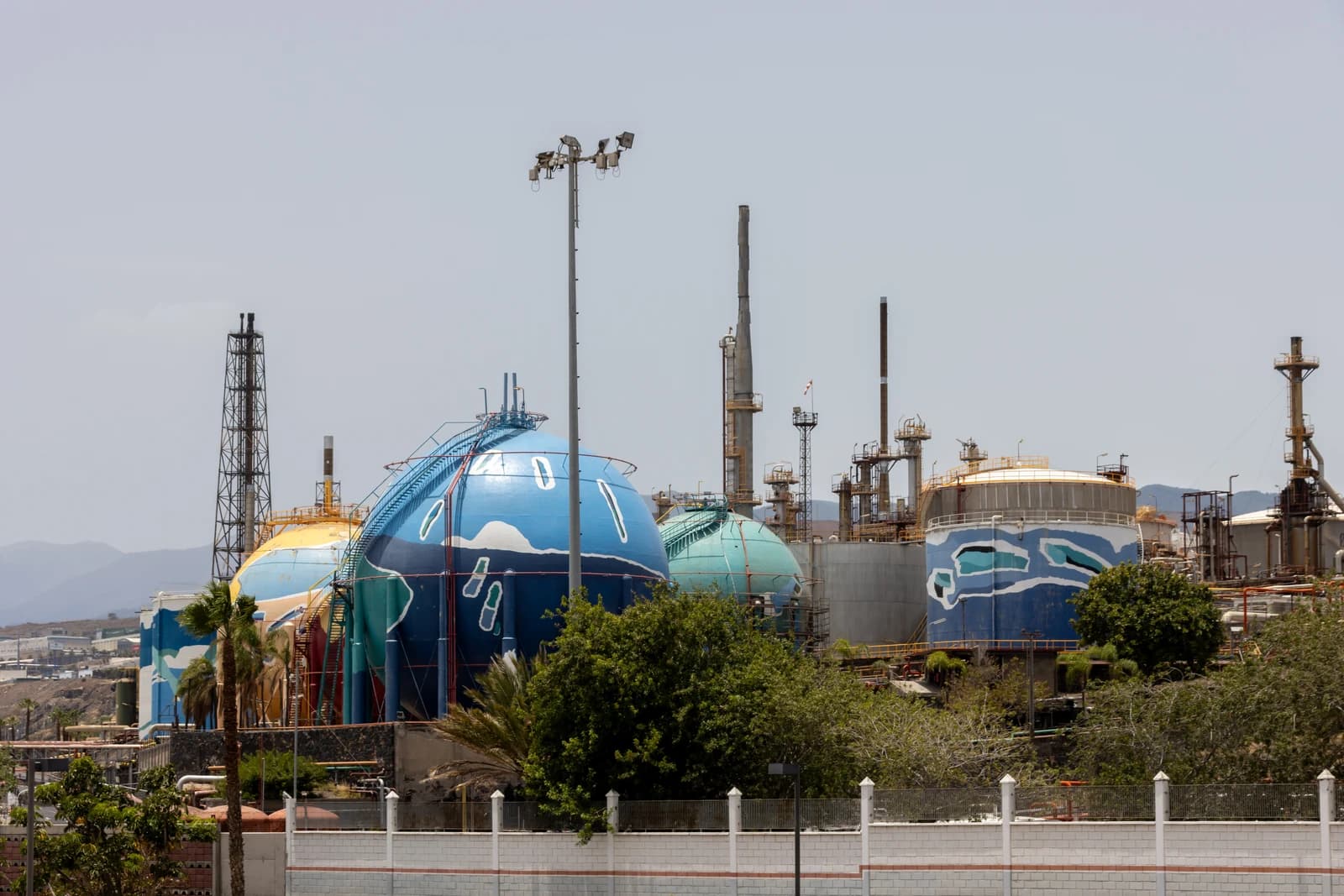 Large colorful spherical and cylindrical storage tanks at an industrial site.