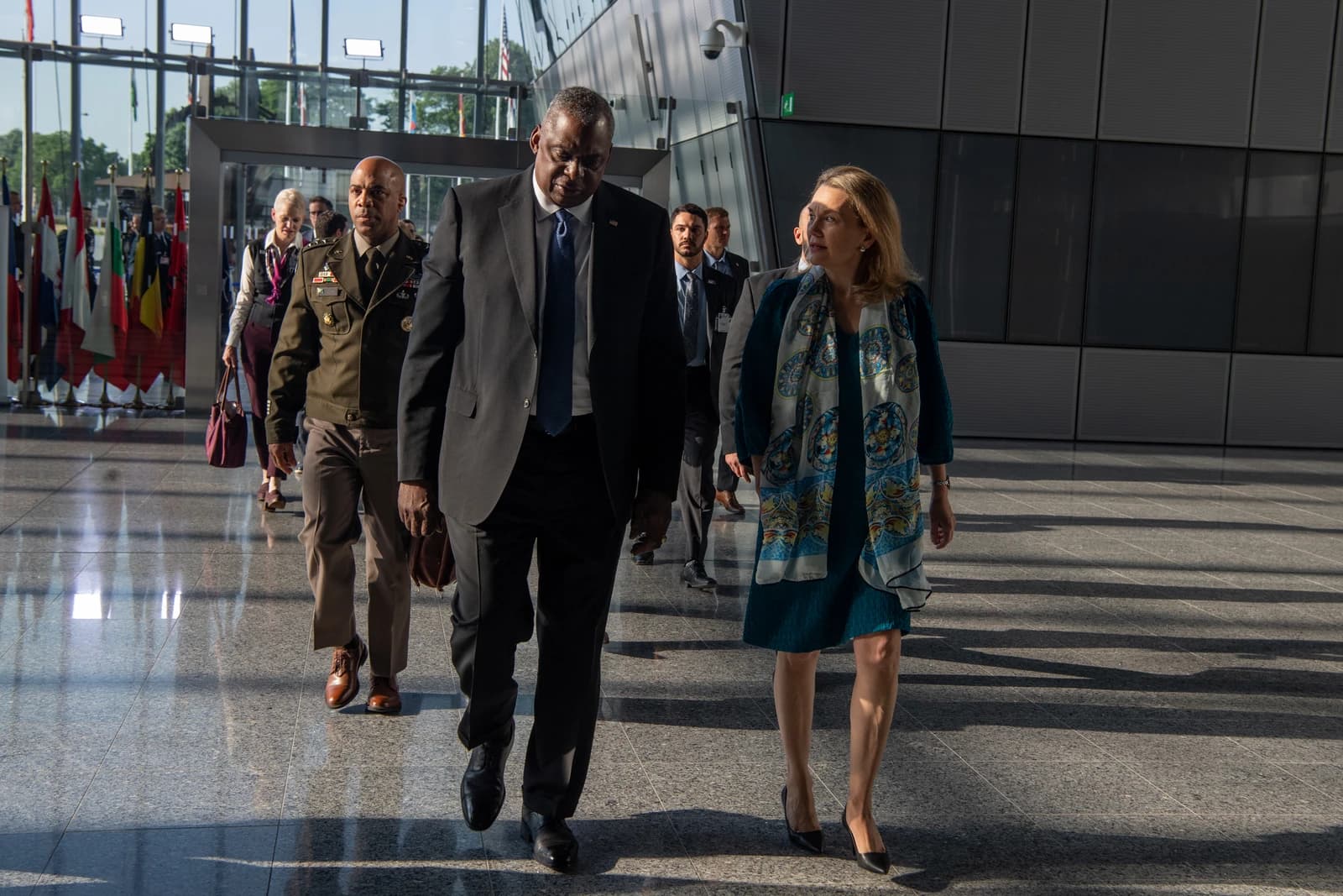 Secretary of Defense Lloyd Austin walking with other officials inside NATO Headquarters.