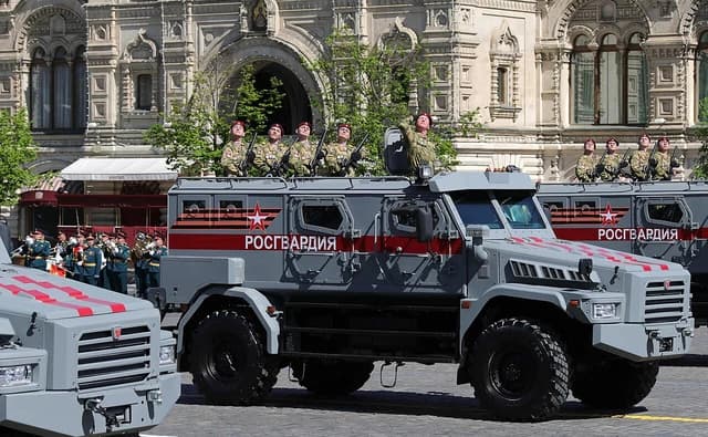 Russian National Guard armored vehicles carrying soldiers during a military parade in Moscow.