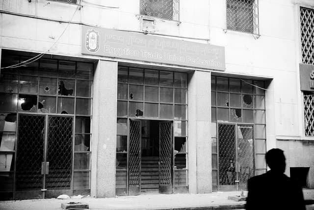 Entrance of the Egyptian Trade Union Federation building, showing broken windows and open doors.