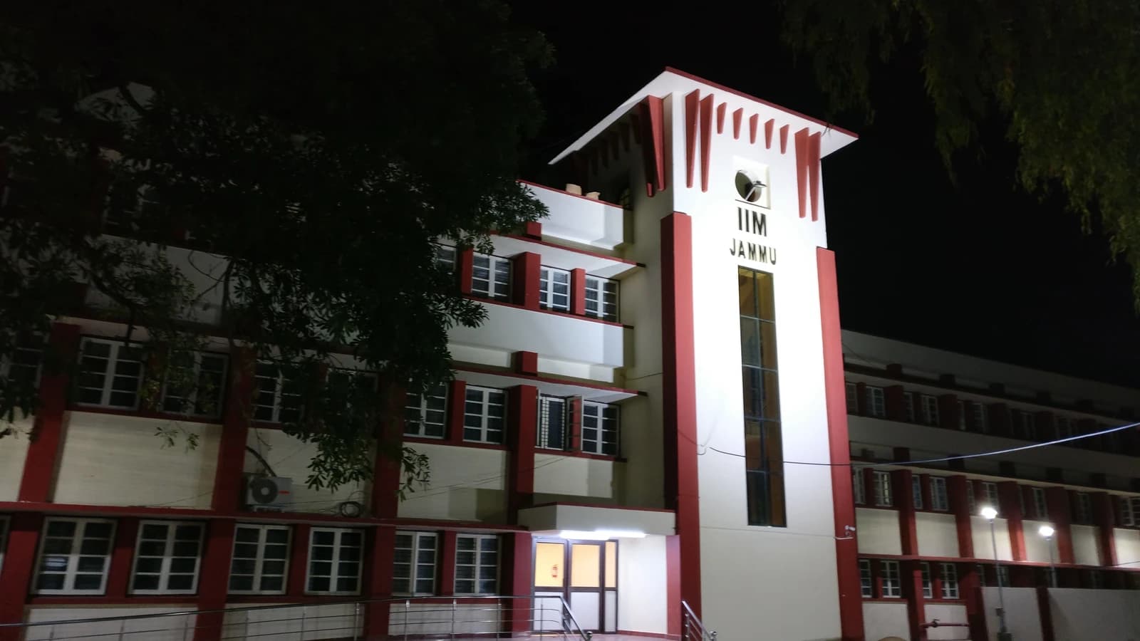 Exterior of the IIM Jammu academic block at night, with a sign visible.