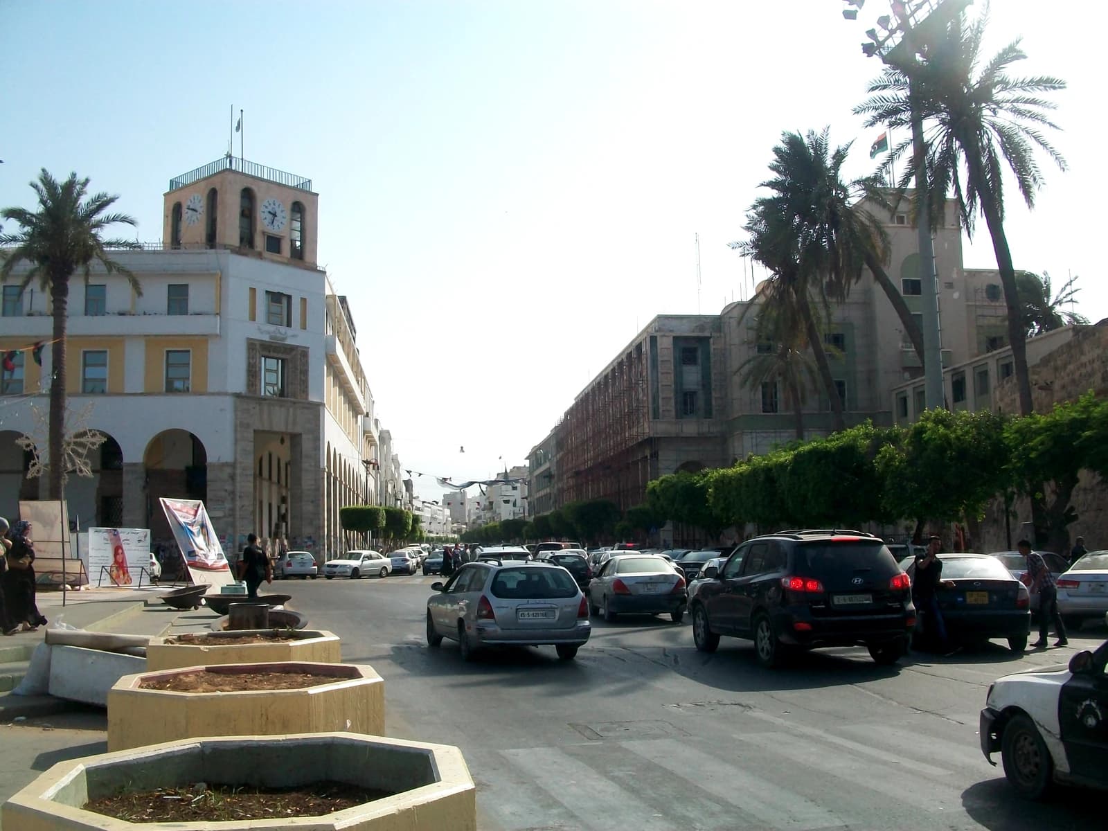 Omar Mukhtar Street in Libya with cars on the road and buildings lining the street.