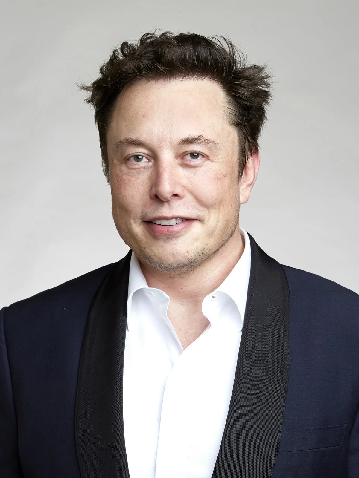 Elon Musk, CEO of Tesla and SpaceX, smiles directly at the camera.