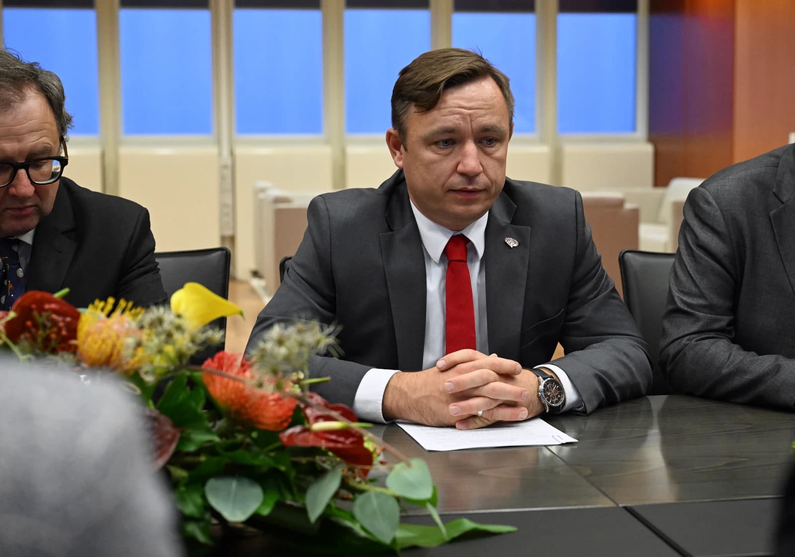 Man in a suit listening intently at the IAEA Poland Bilateral Meeting.