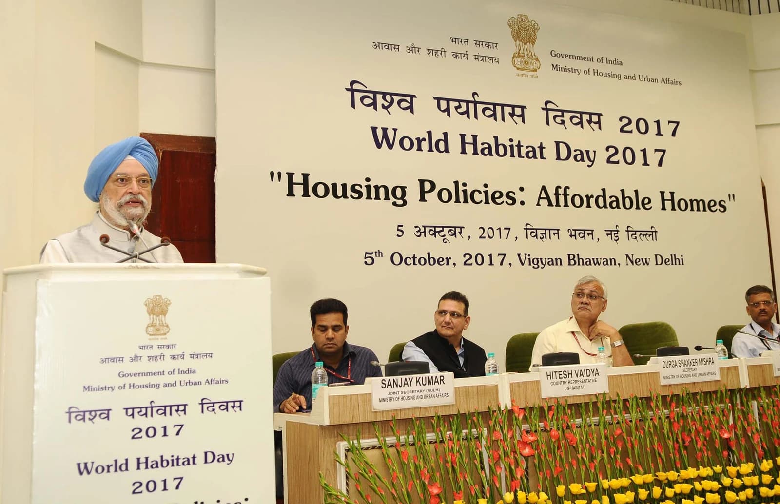 Hardeep Singh Puri, Minister of State for Housing and Urban Affairs, speaking at a podium.