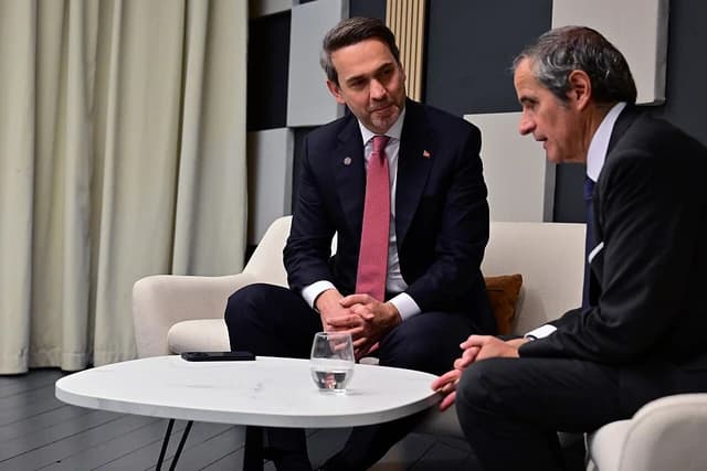 Alparslan Bayraktar, Turkey's Minister of Energy and Natural Resources, sitting and talking with another man.