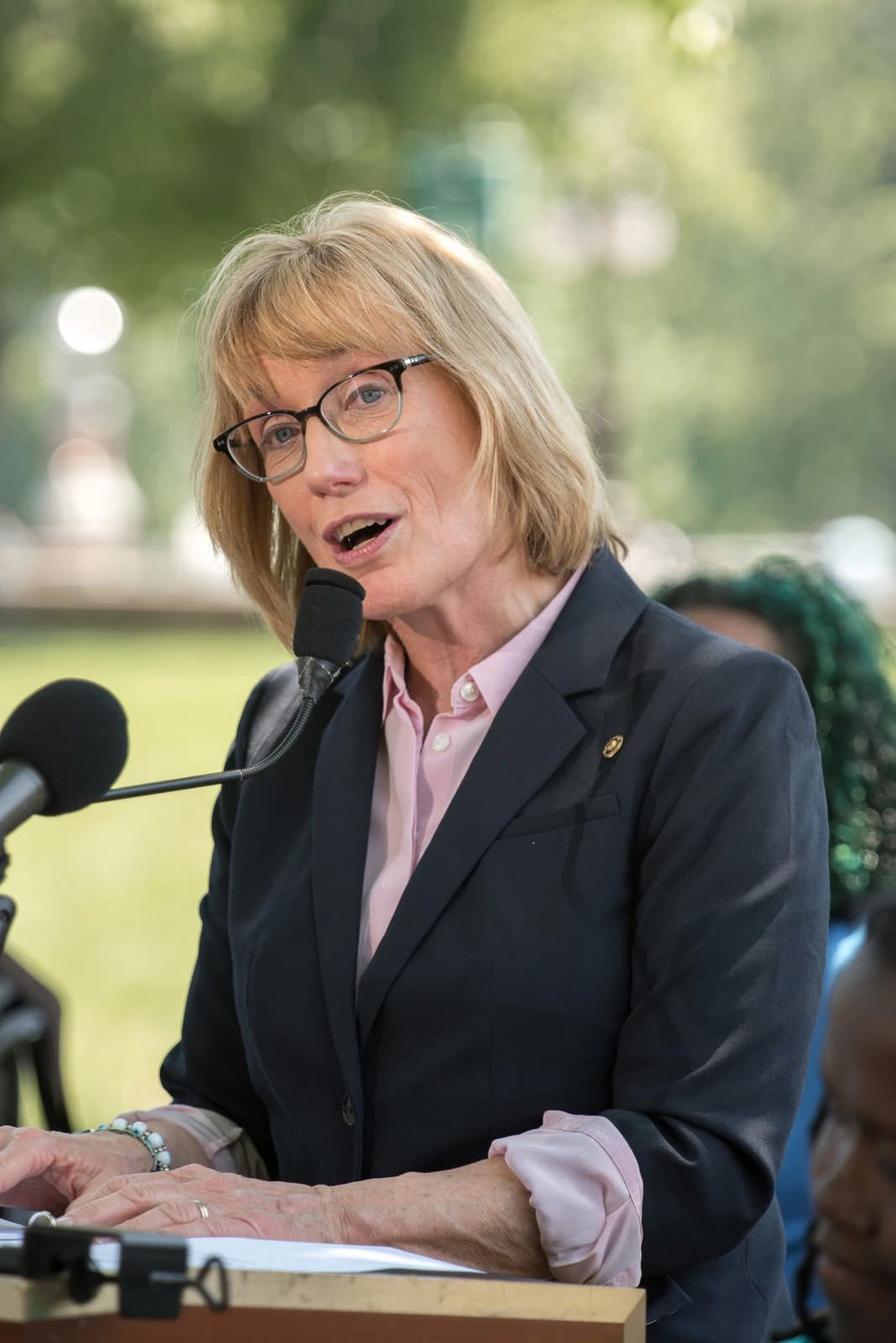 Senator Maggie Hassan speaking at a press conference outdoors.