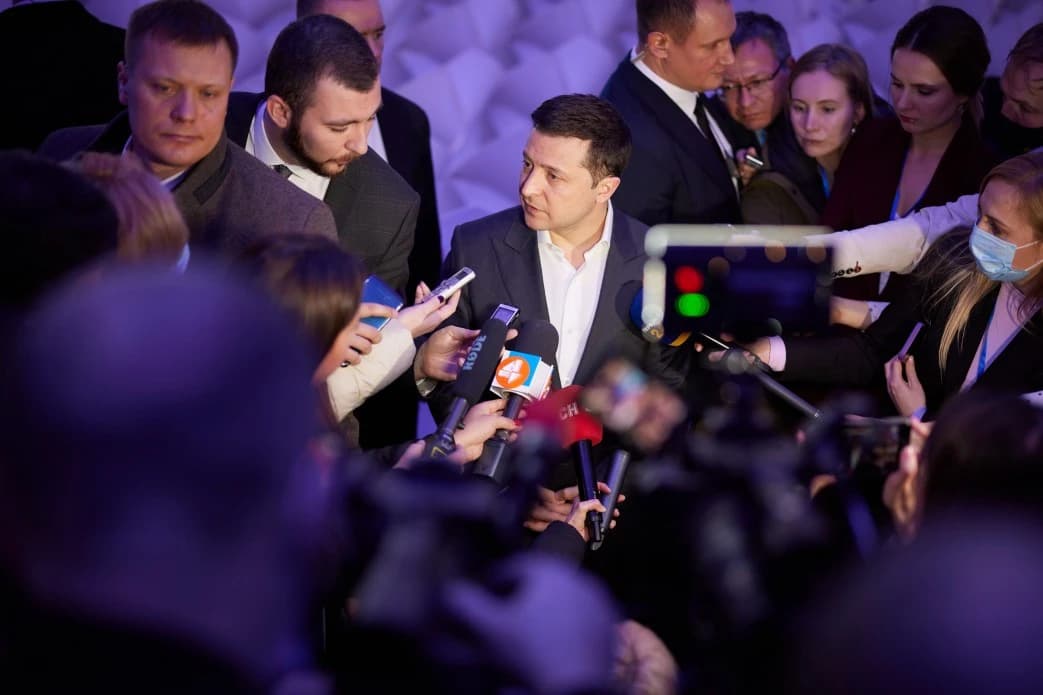 Ukrainian President Volodymyr Zelenskyy speaks to reporters and microphones at a conference.