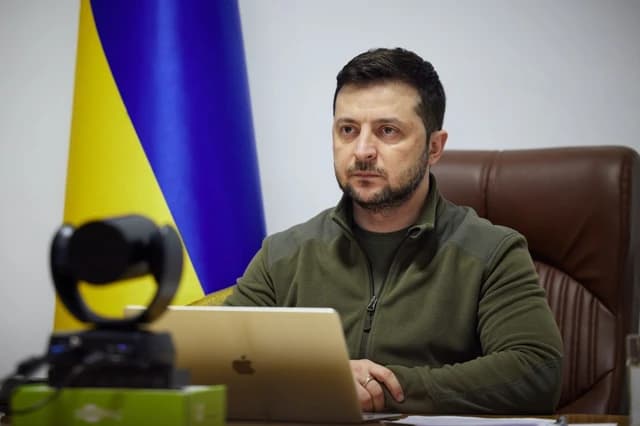 Volodymyr Zelenskyy, President of Ukraine, speaking from a desk during an address.