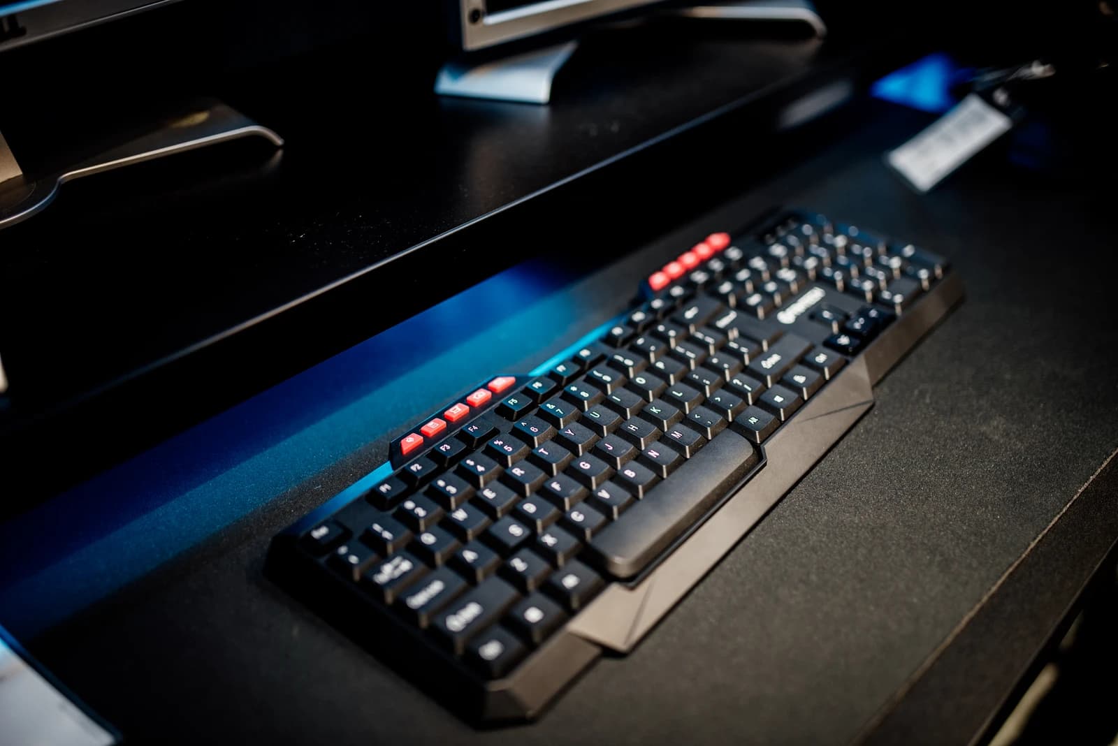 Computer keyboard placed on a black desk in a modern workspace.
