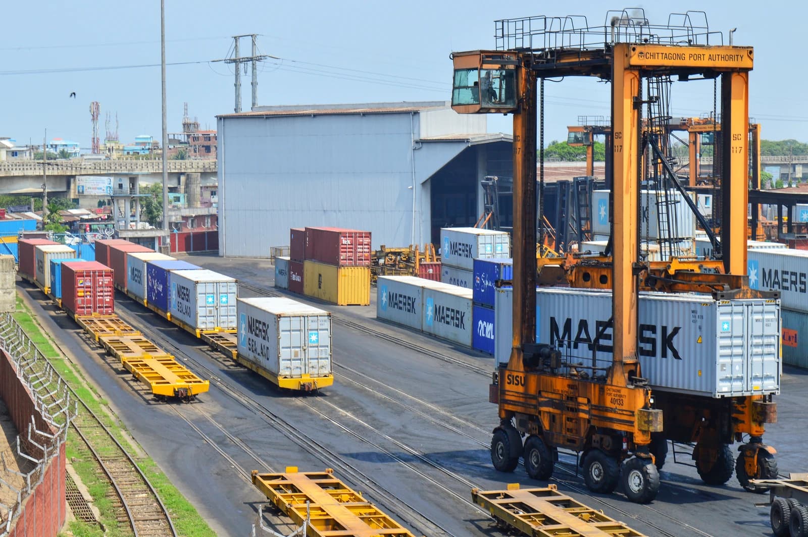 A straddle carrier lifts a shipping container at the Port of Chittagong in Bangladesh.