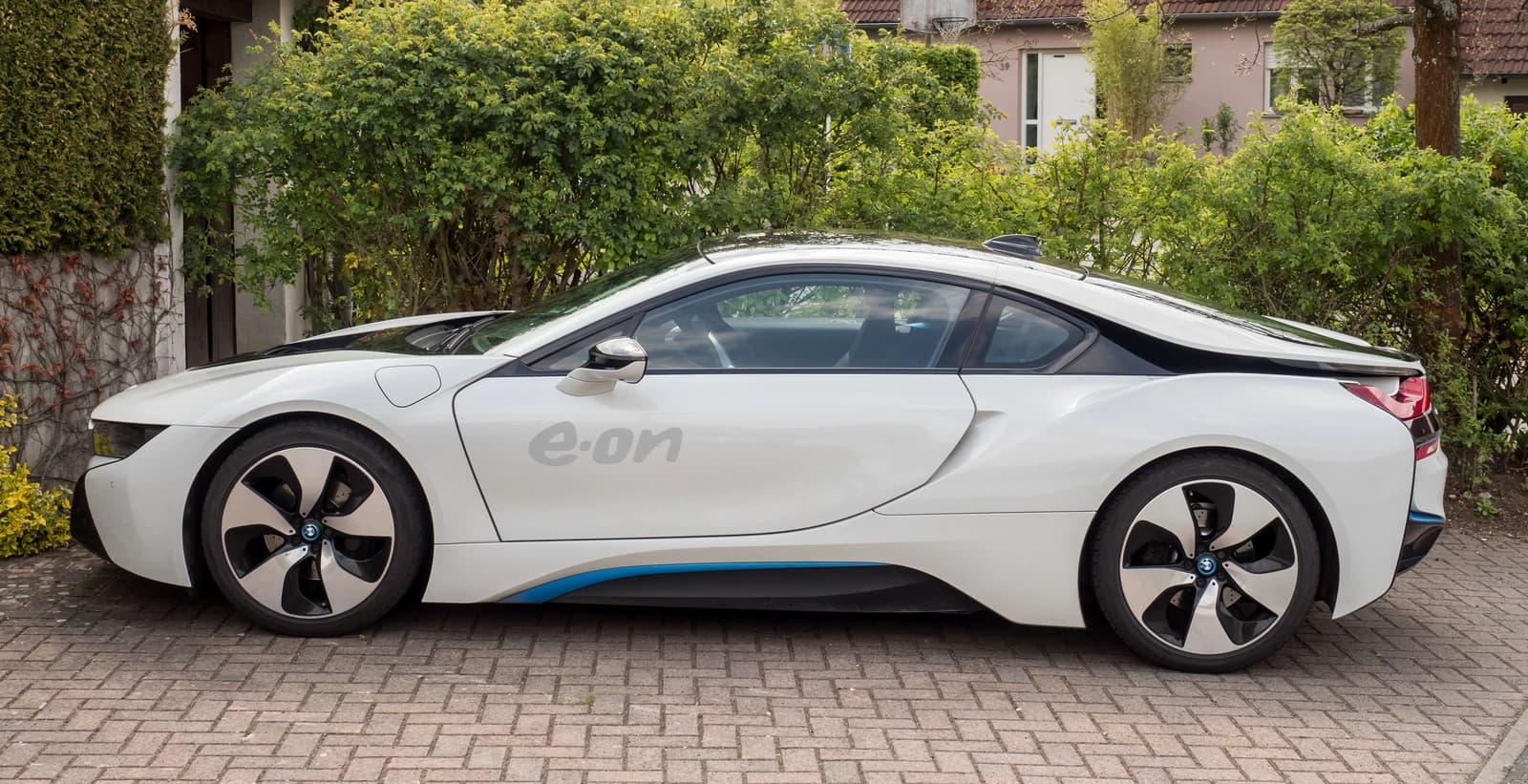White BMW i8 electric sports car with blue accents parked outdoors.