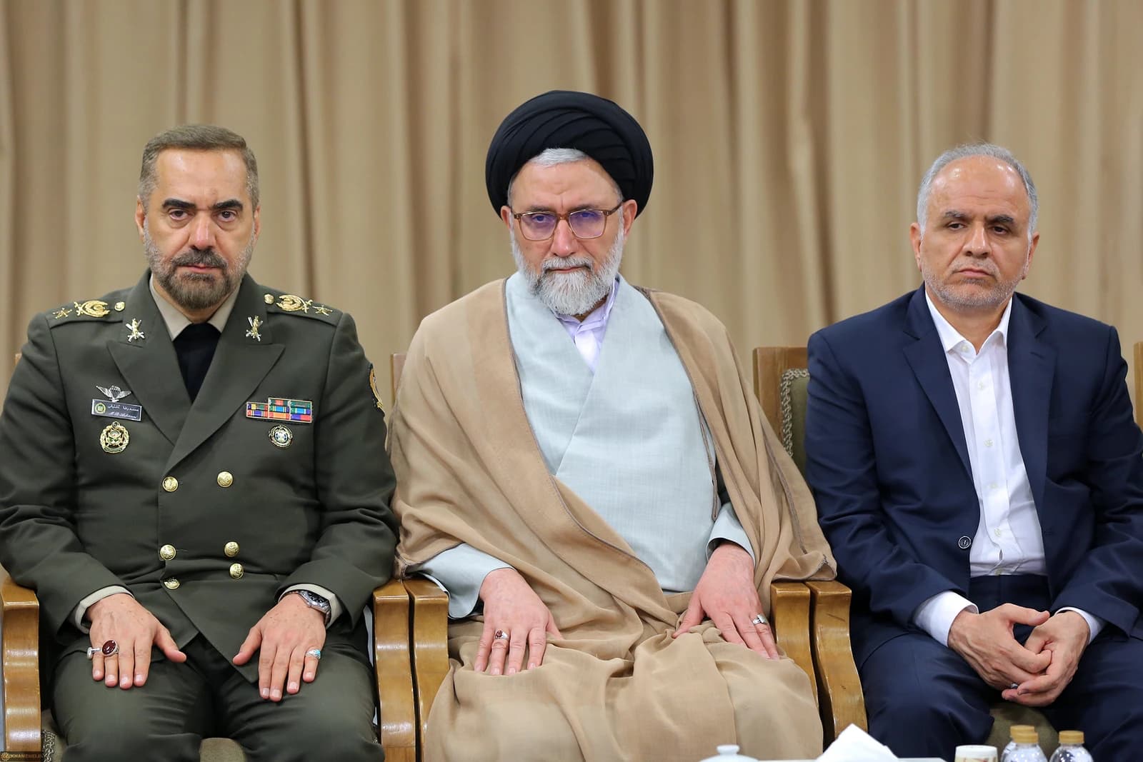 Mohammad-Reza Ashtiani, Iran's Defense Minister, seated in uniform with two other men.