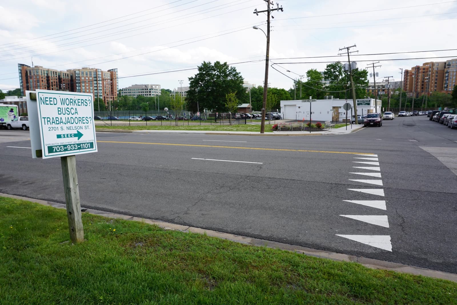 Bilingual sign with "Need Workers?" and "Busca Trabajadores?" in Arlington, Virginia.