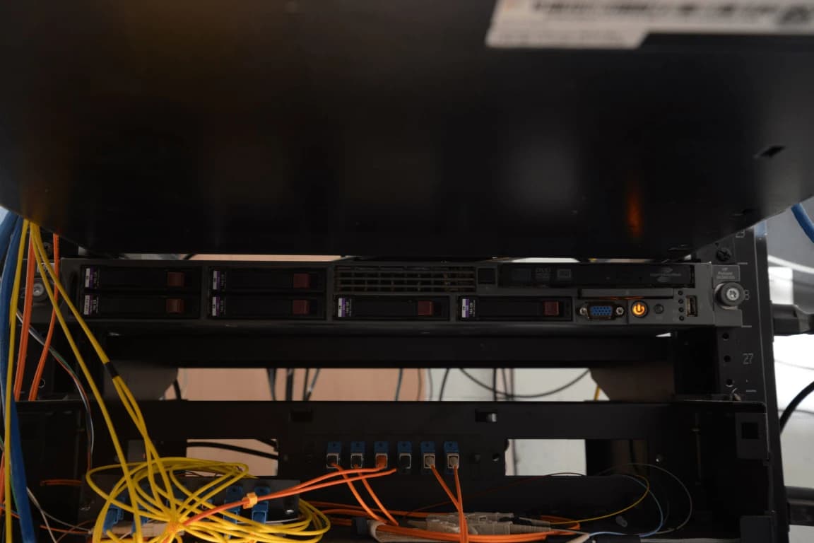 Server rack with multiple hard drives and network cables in a data center.