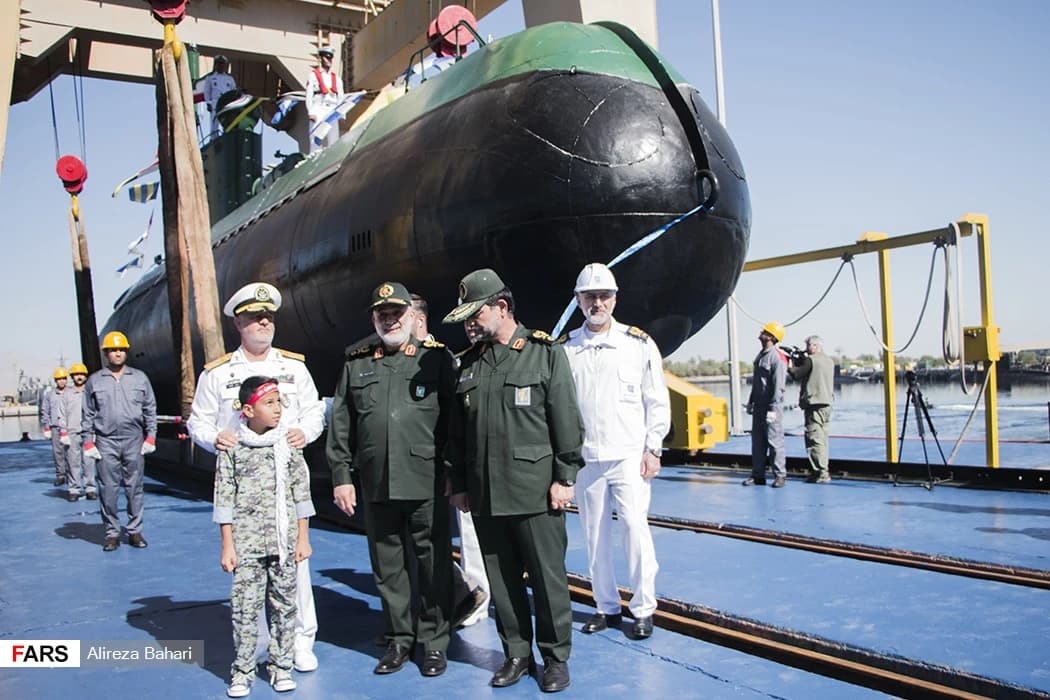 Military and naval officers with a boy at the commissioning of a submarine.