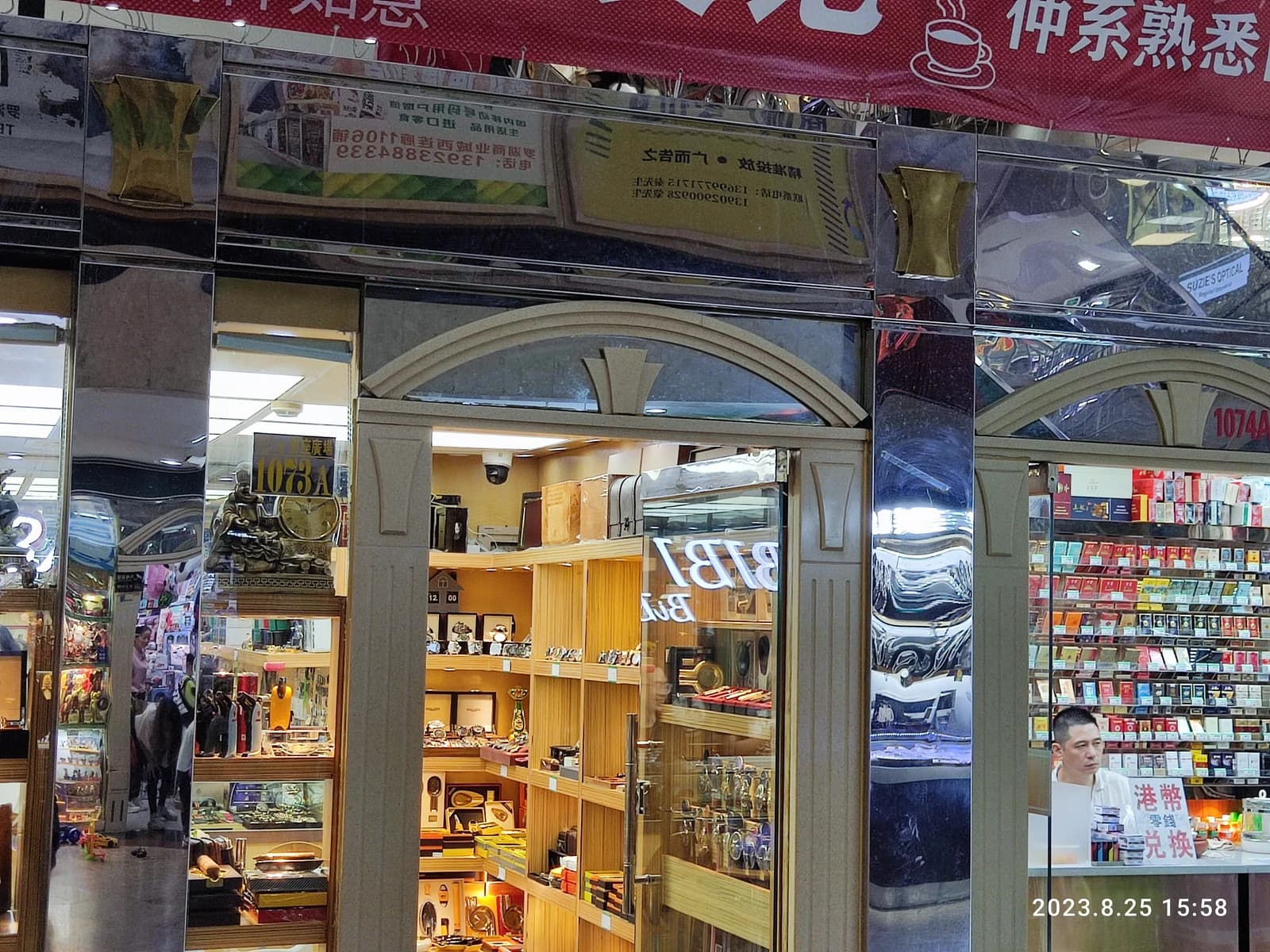 Shopfront displaying various luxury goods, with a man standing inside, in Luohu Commercial City.