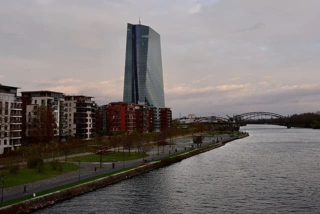 European Central Bank Headquarters building with a river and buildings in the foreground.