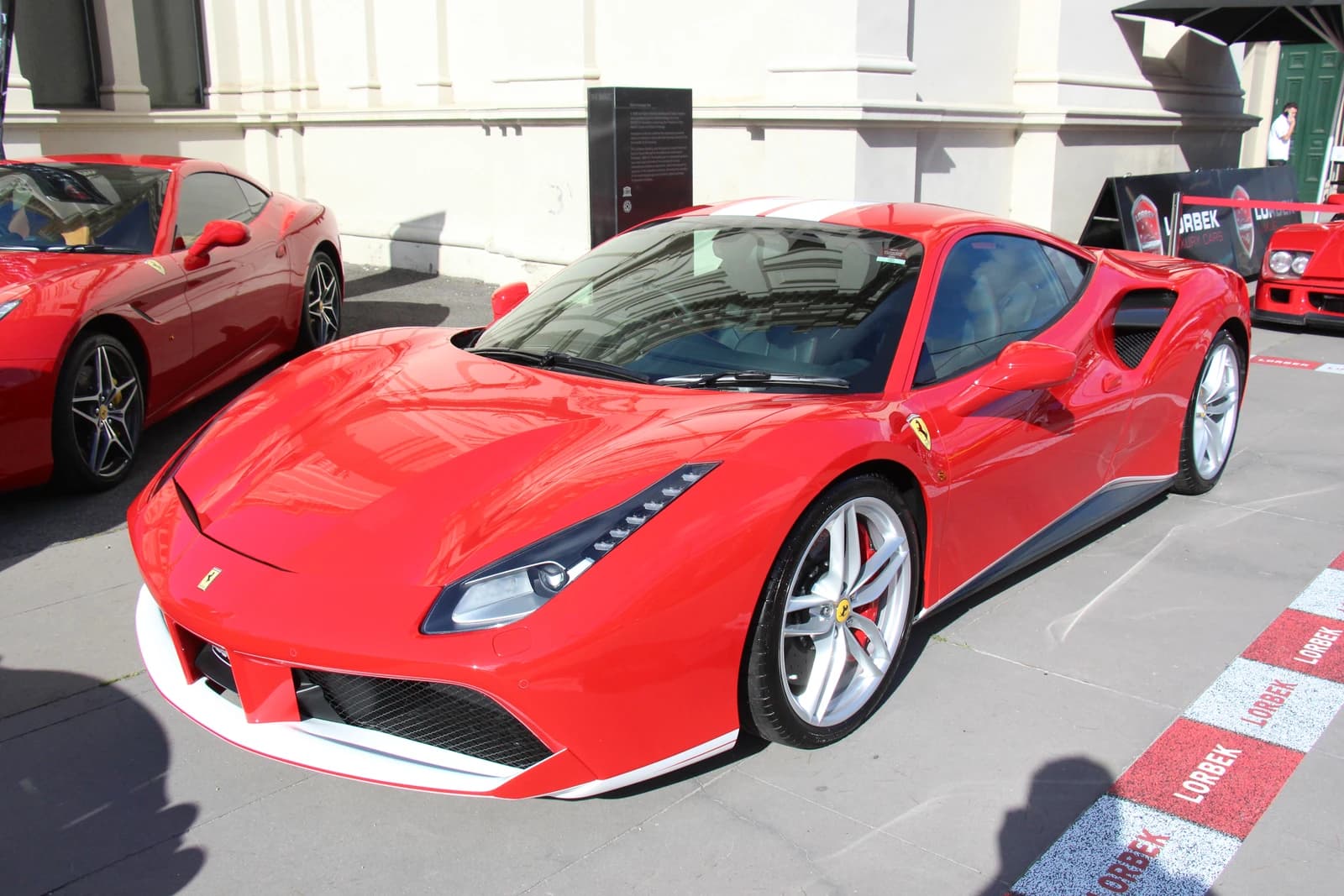 A red 2016 Ferrari 488 GTB Berlinetta supercar is parked outdoors.