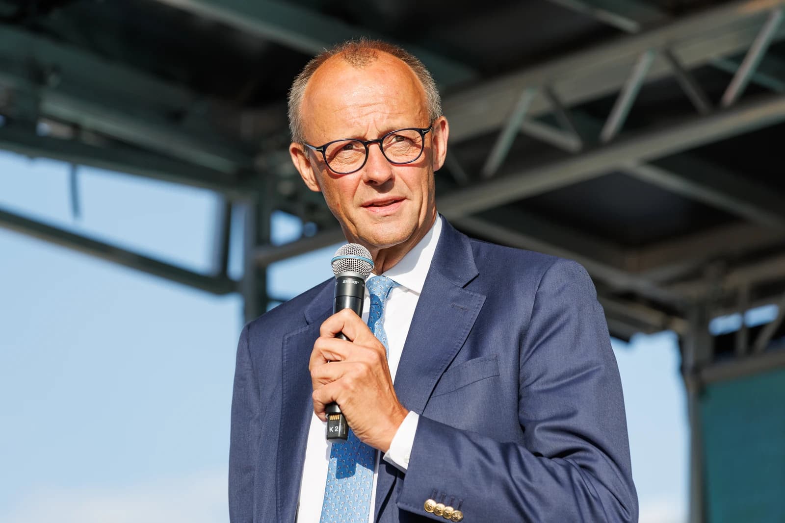 Friedrich Merz, German politician, speaking into a microphone at an outdoor event.