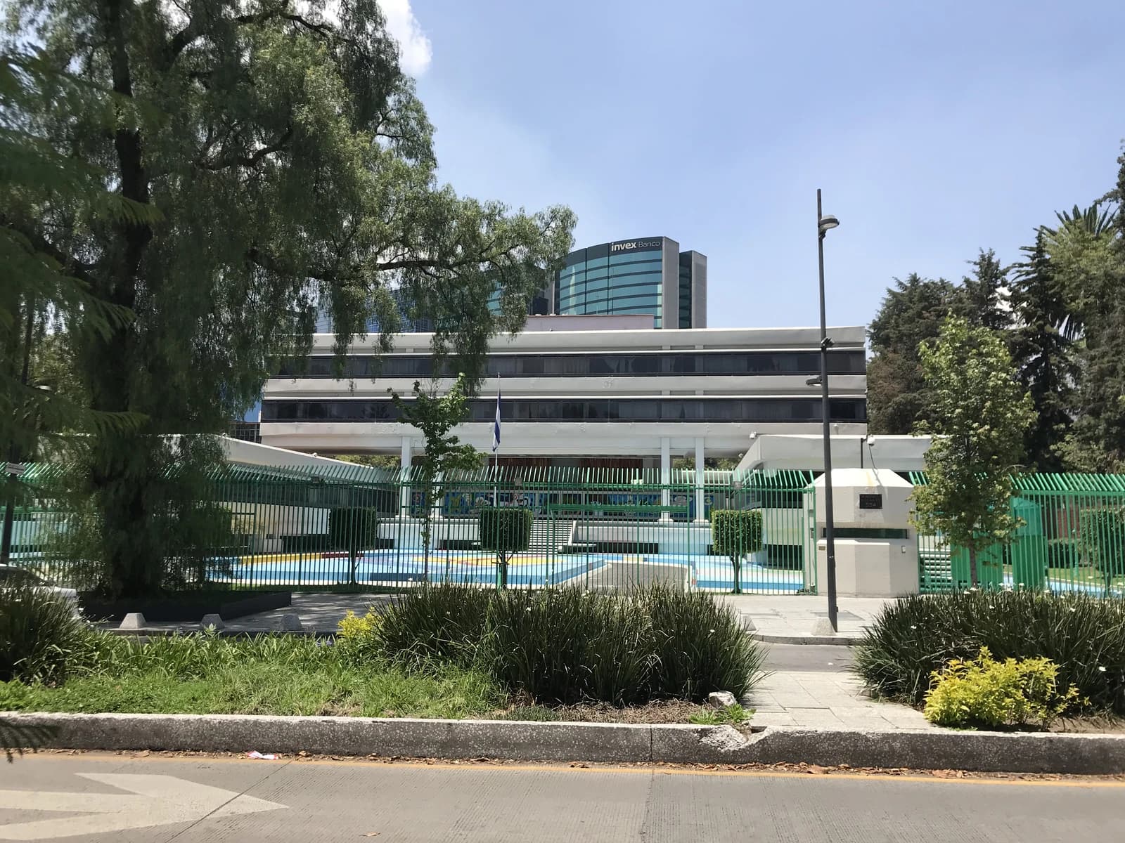 Exterior view of the Embassy of Cuba in Mexico City, Mexico, with a modern building and green fence.