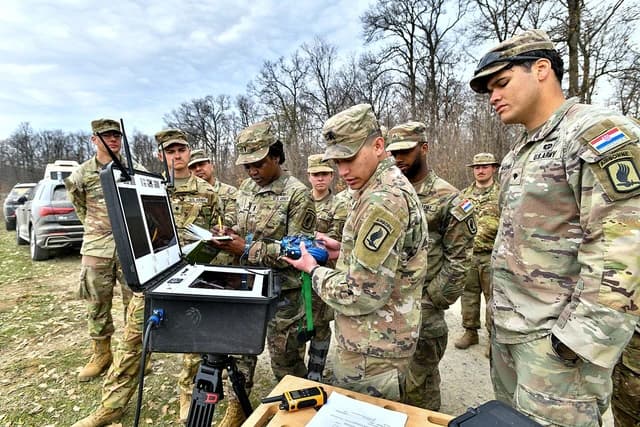 US Army soldiers operate drone control equipment during a test outdoors.