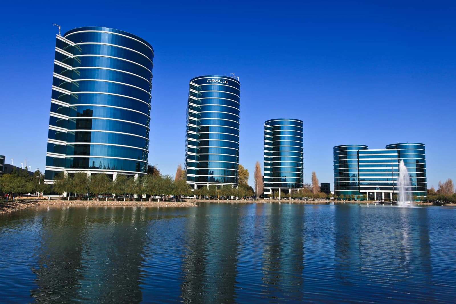 Oracle Corporation headquarters buildings in Redwood Shores, California, reflected in a lake.