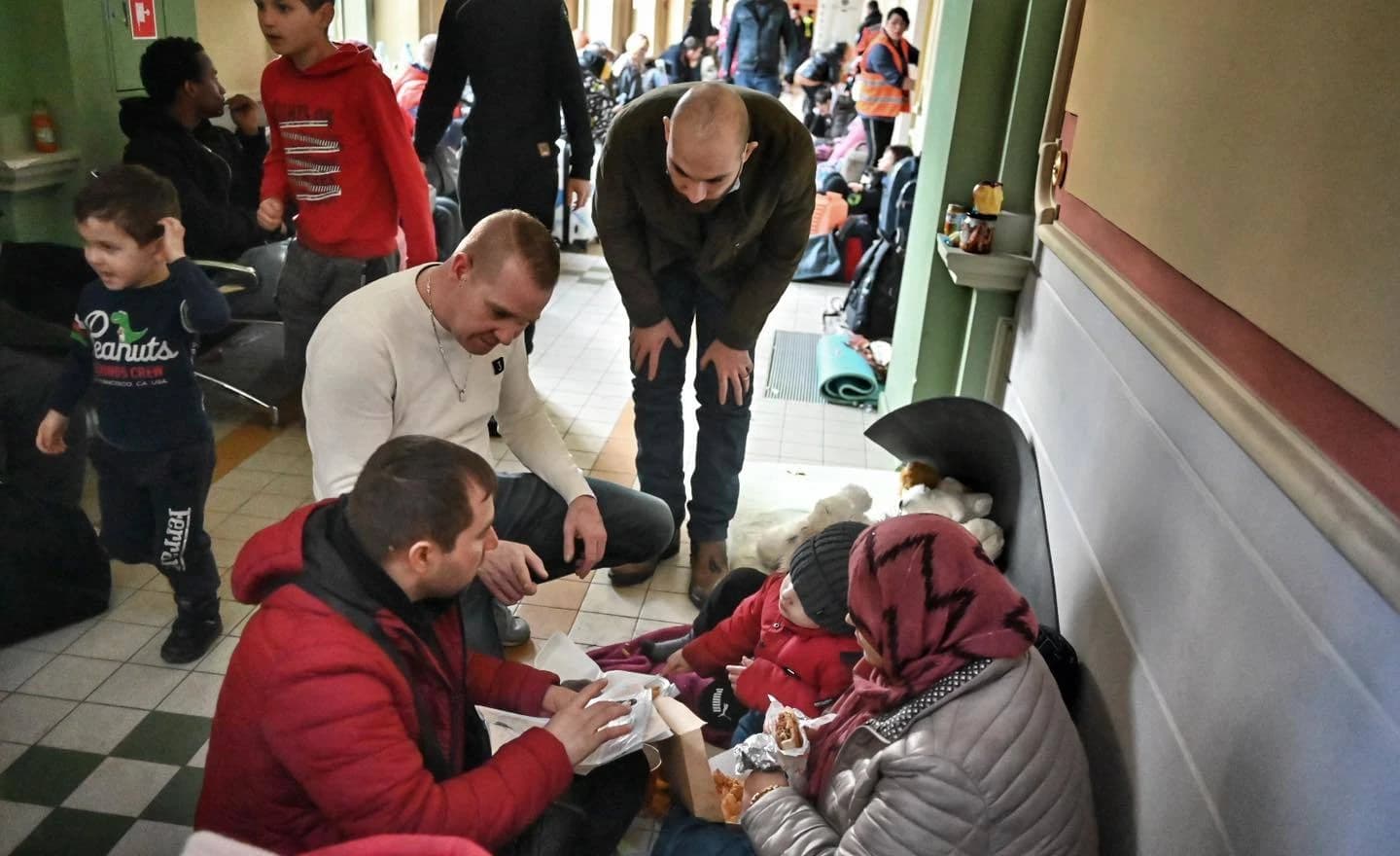 Ukrainian refugees rest on the floor of a train station near the Polish border.