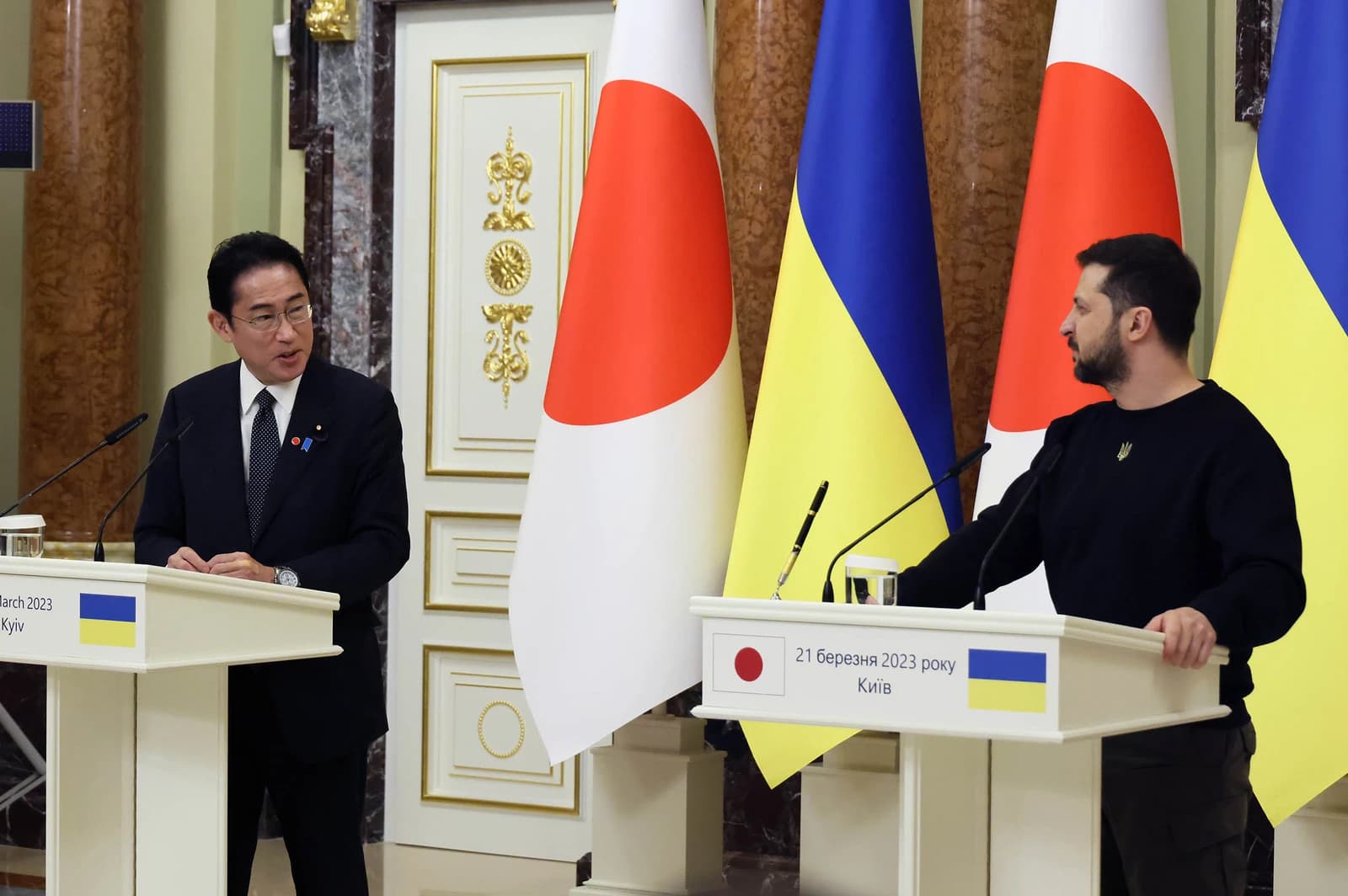 Fumio Kishida, Prime Minister of Japan, and Volodymyr Zelenskyy, President of Ukraine, standing at podiums.