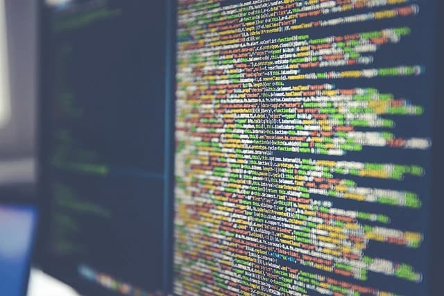 Colorful programming code displayed across a dark computer monitor.