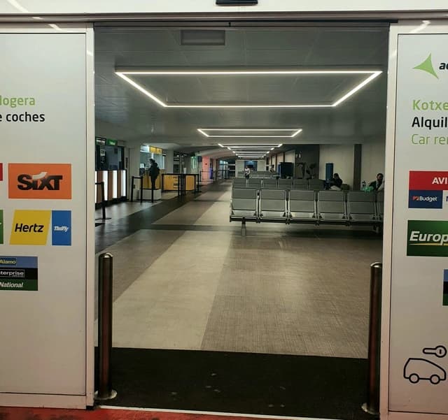 Entrance to a car rental office area within an airport terminal.