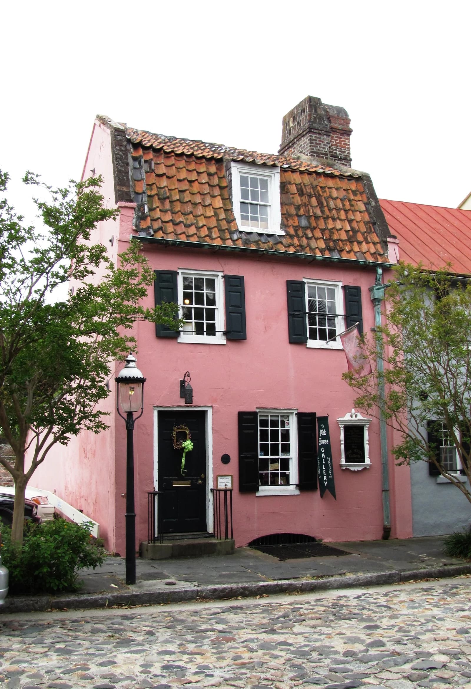 Pink House, a historic pink building with dark shutters and a red-tiled roof, in Charleston, South Carolina.