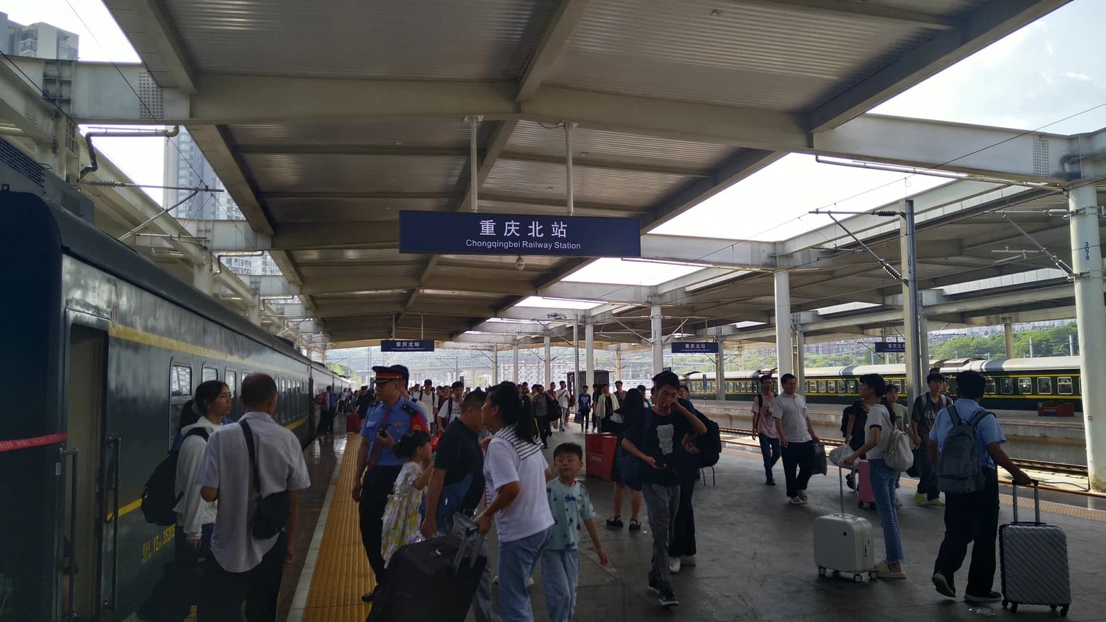 People with luggage walking on a train platform at Chongqingbei Railway Station.