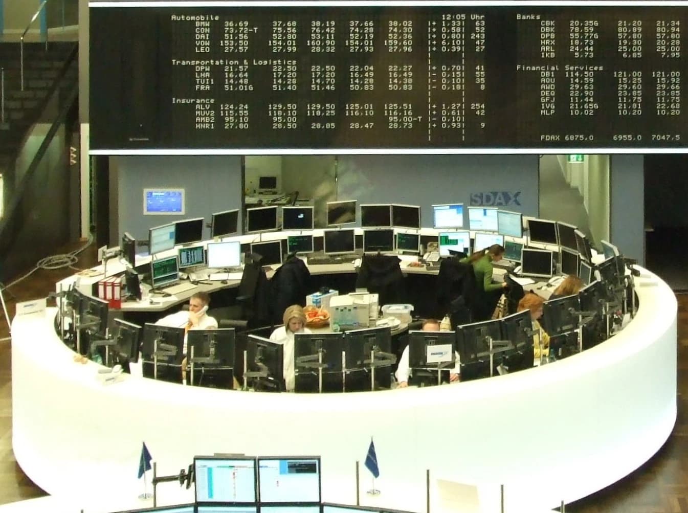 Stockbrokers work on computers and talk on phones at a trading desk.