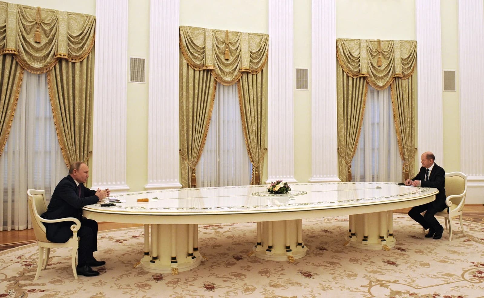 Russian President Vladimir Putin and German Chancellor Olaf Scholz sit far apart at a very long table.