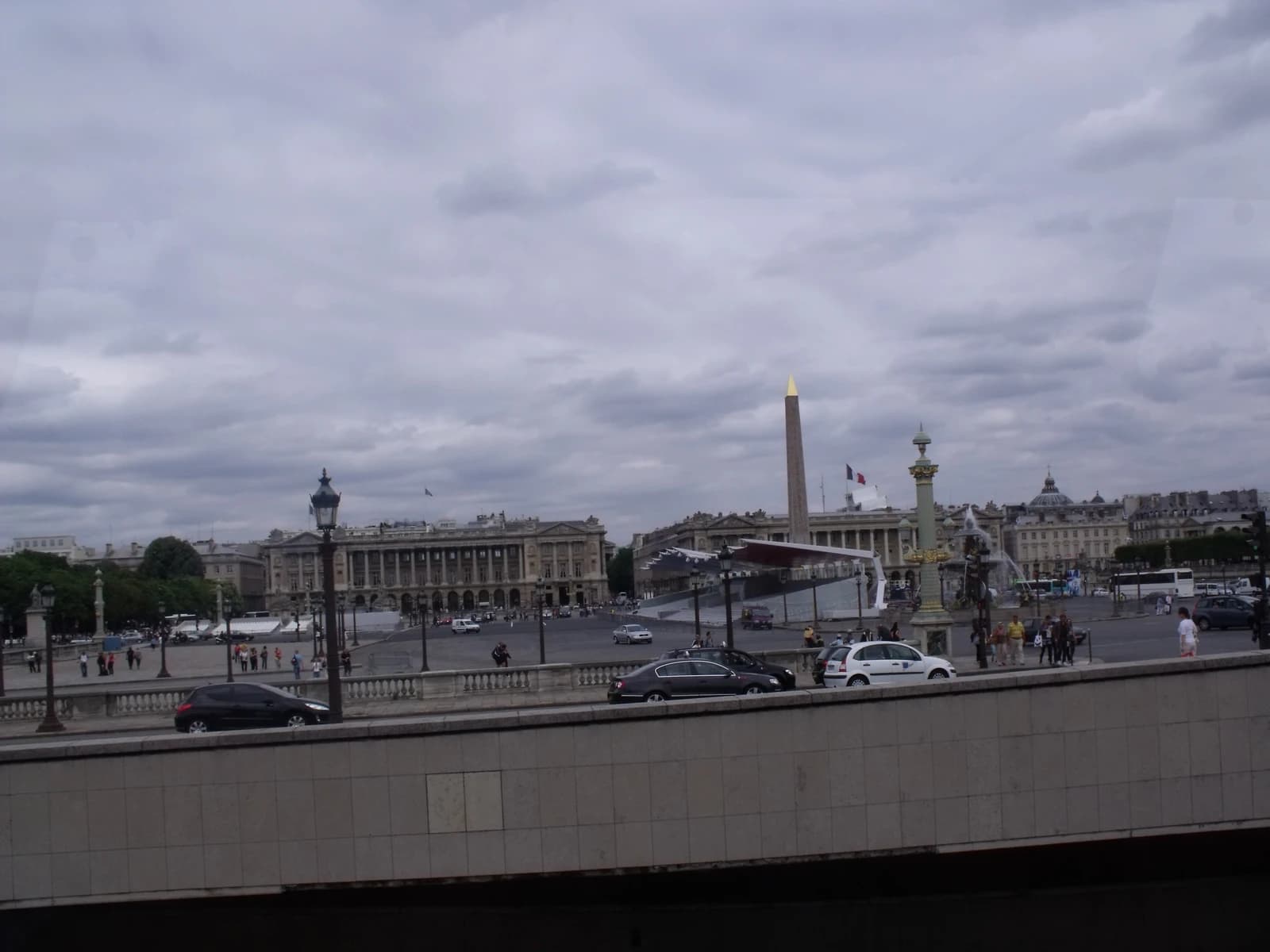 The Luxor Obelisk stands in Place de la Concorde with buildings and traffic visible.