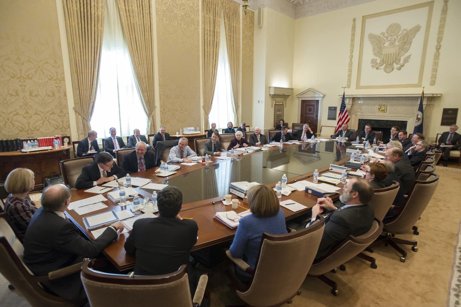 Federal Open Market Committee members seated around a large polished conference table in a meeting room.