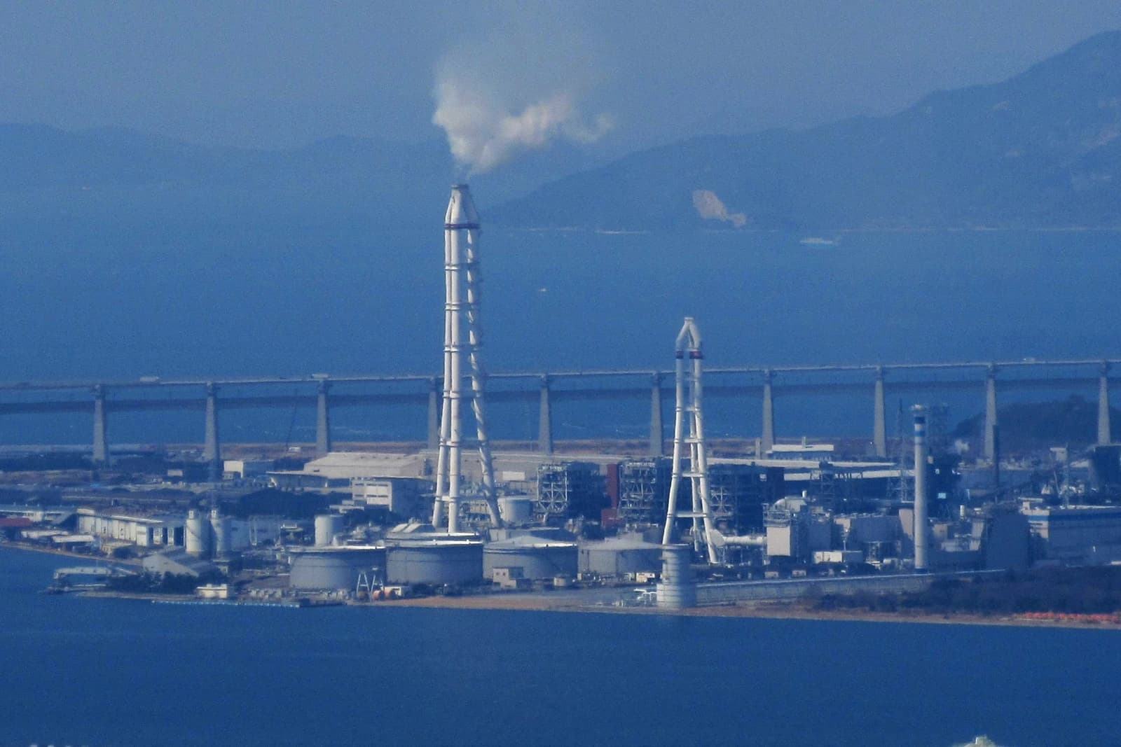 Yonden Sakaide Power Plant with smokestacks near the coast in Japan.
