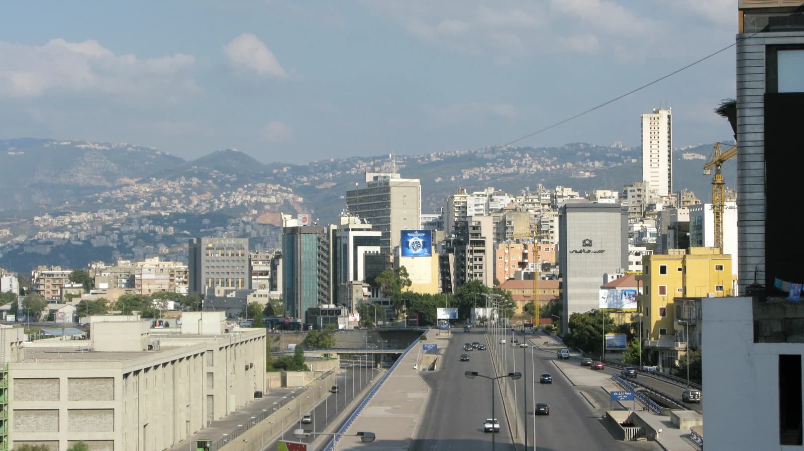 A panoramic view of the Beirut skyline with buildings and mountains in the background.
