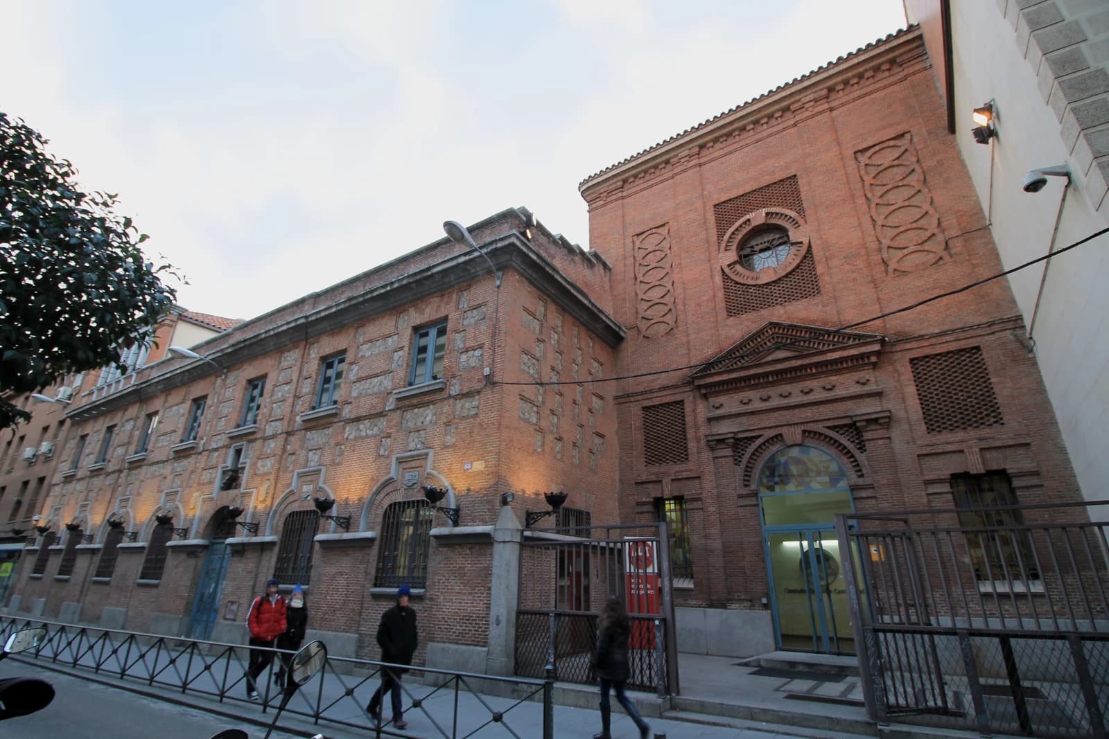 Brick building with ornate window and entrance, identified as UGT social headquarters in Madrid.