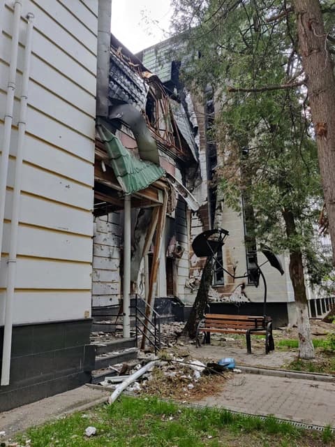 A damaged building with debris and shattered windows in Irpin, Ukraine.