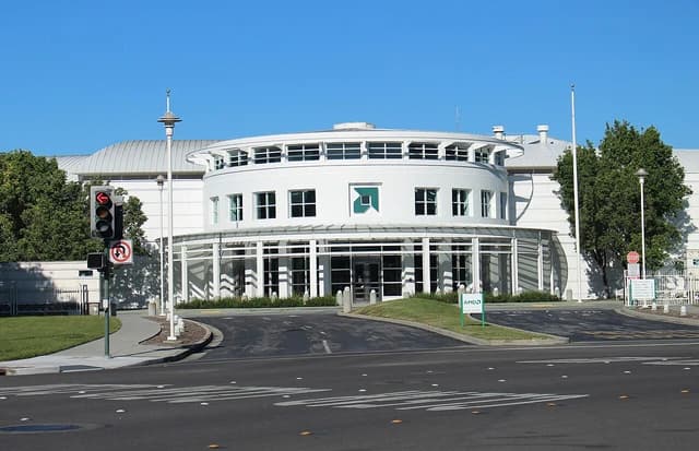 Exterior view of an AMD corporate office building with a small AMD sign near the entrance.