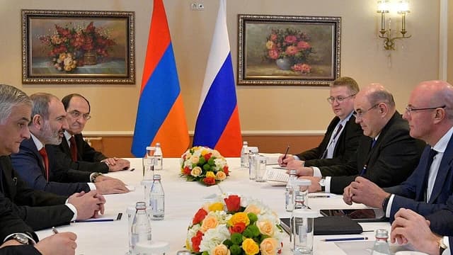 Mikhail Mishustin, Prime Minister of Russia, and Nikol Pashinyan, Prime Minister of Armenia, seated at a conference table.